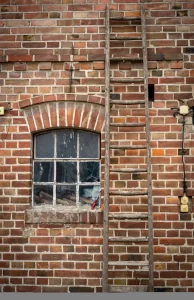 ladder leaning on a red brick building