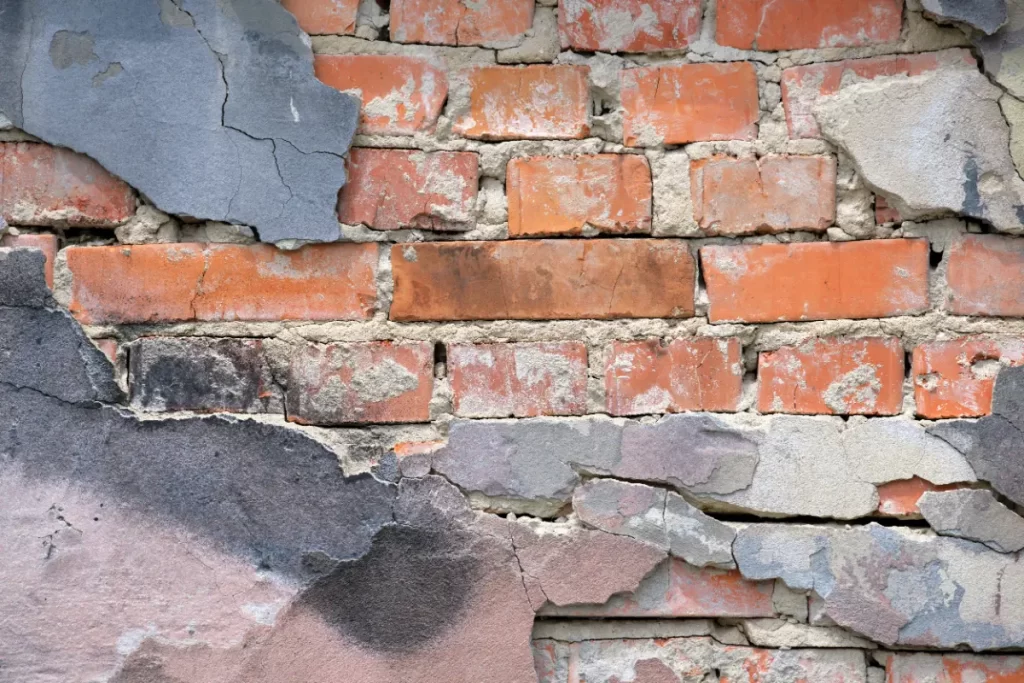 old brick wall texture with cracked peeling paint